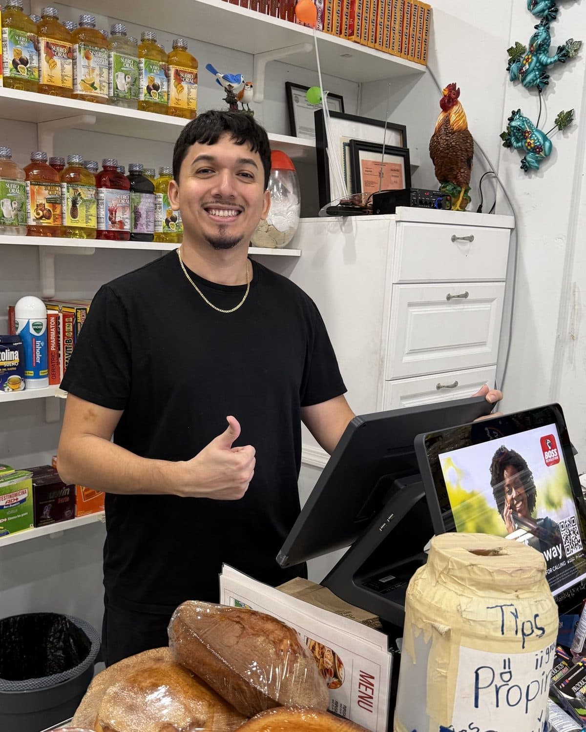 Santos Diaz giving a thumbs-up next to a POS system he installed at a client's Hispanic grocery store